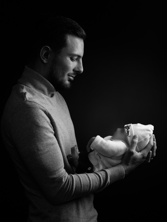 Portrait d'un papa portant son enfant, à l'occasion d'une grossesse, pris en studio par un photographe à Tours